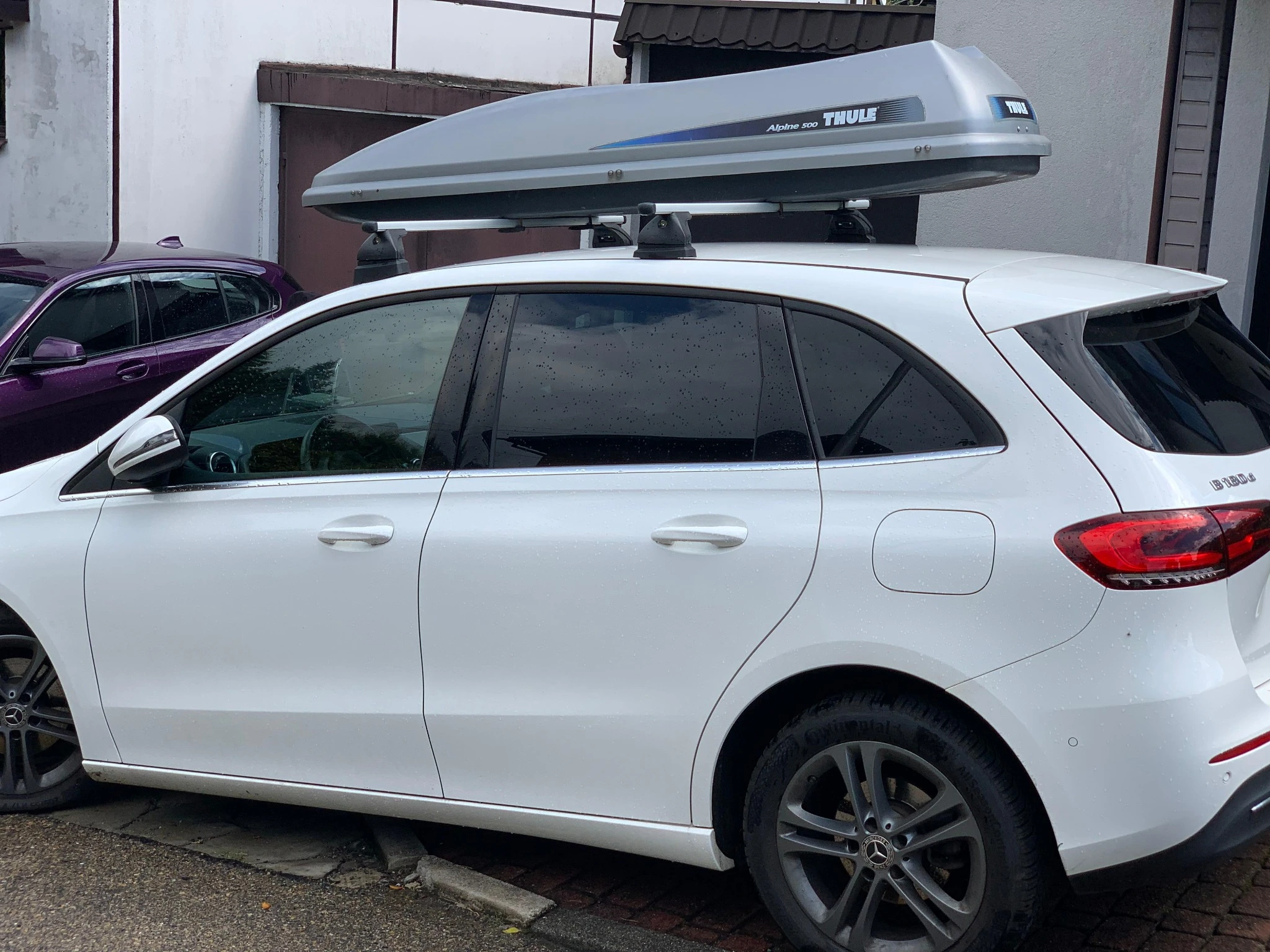 Box dachowy Thule Alpine 500 widziany z boku, zamontowany na belkach dachowych samochodu