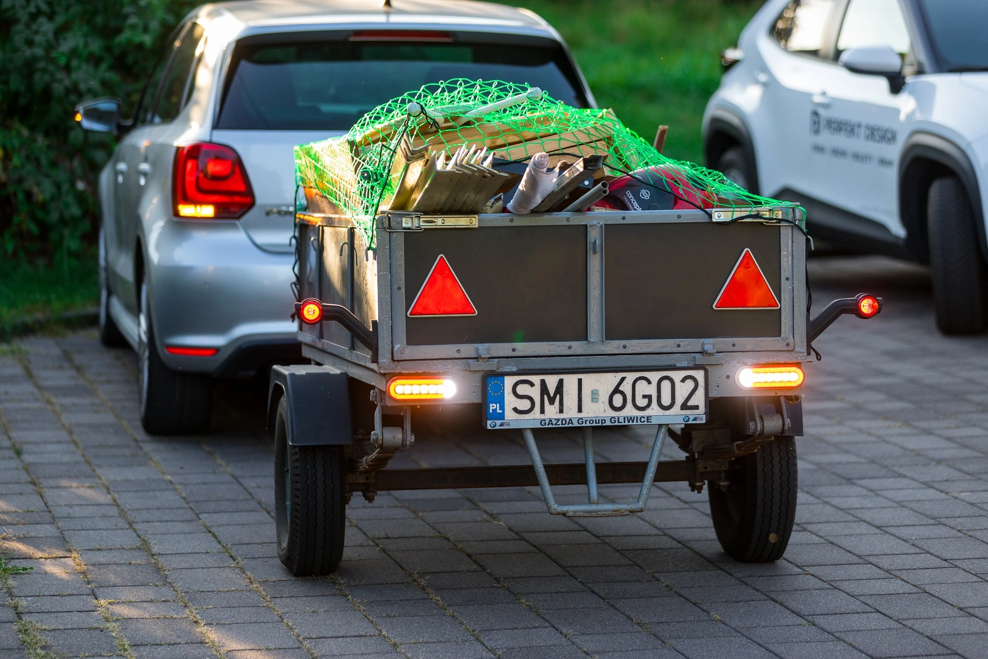 Tył przyczepy S-250 z włączonym oświetleniem i ładunkiem zabezpieczonym siatką